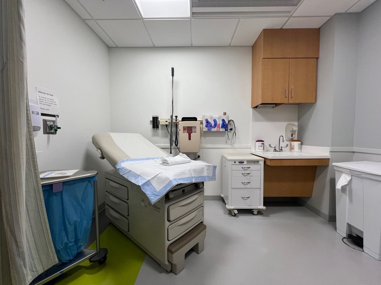 why-choose-us A modern hospital examination room featuring medical equipment and clean furnishings.
