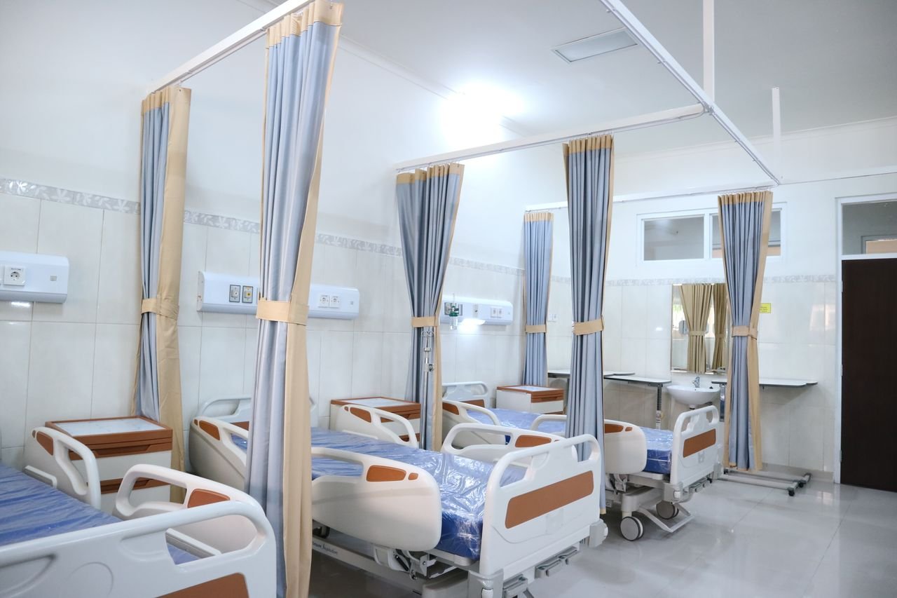 services-01 Spacious hospital ward with modern equipment and private patient areas.